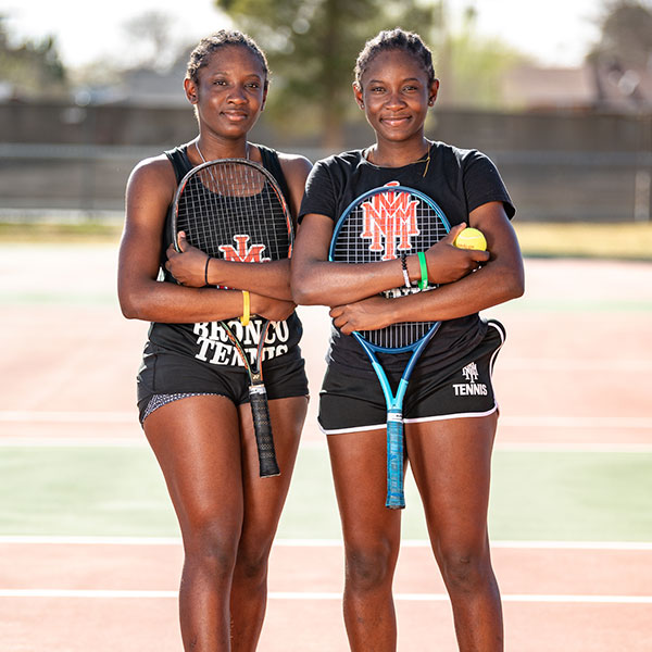 NMMI Tennis Two cadets on a tennis court holding rackets and a tennis ball